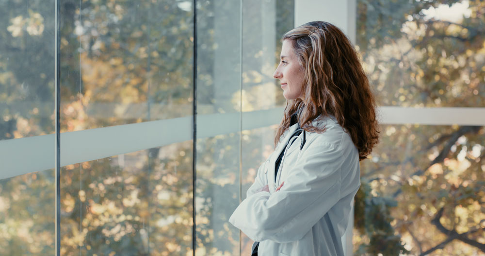 Healthcare professional looking out a window at nature